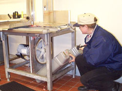 Heidi conducts sanitary inspection on a bandsaw