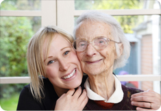 a young woman embraces a woman in her eighties or nineties