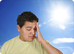 man holding his head in hot sun