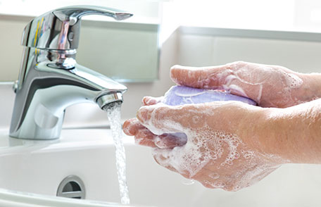 someone washing their hands with soap