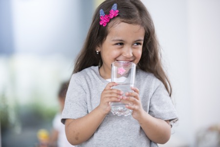 A young girl with a glass of water