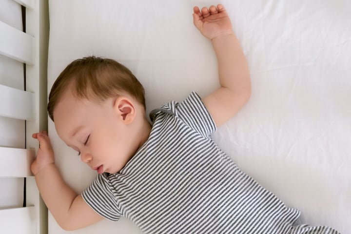 Photograph of baby sleeping on its back