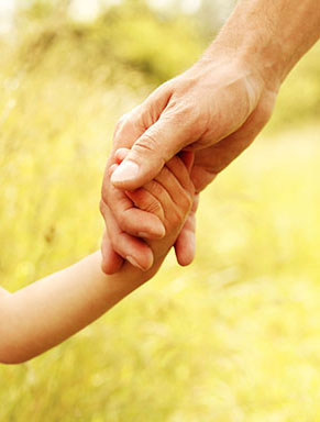 Closeup of adult holding child's hand