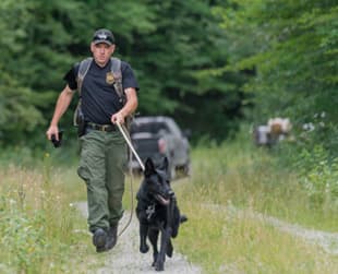 Game Warden walking with K9