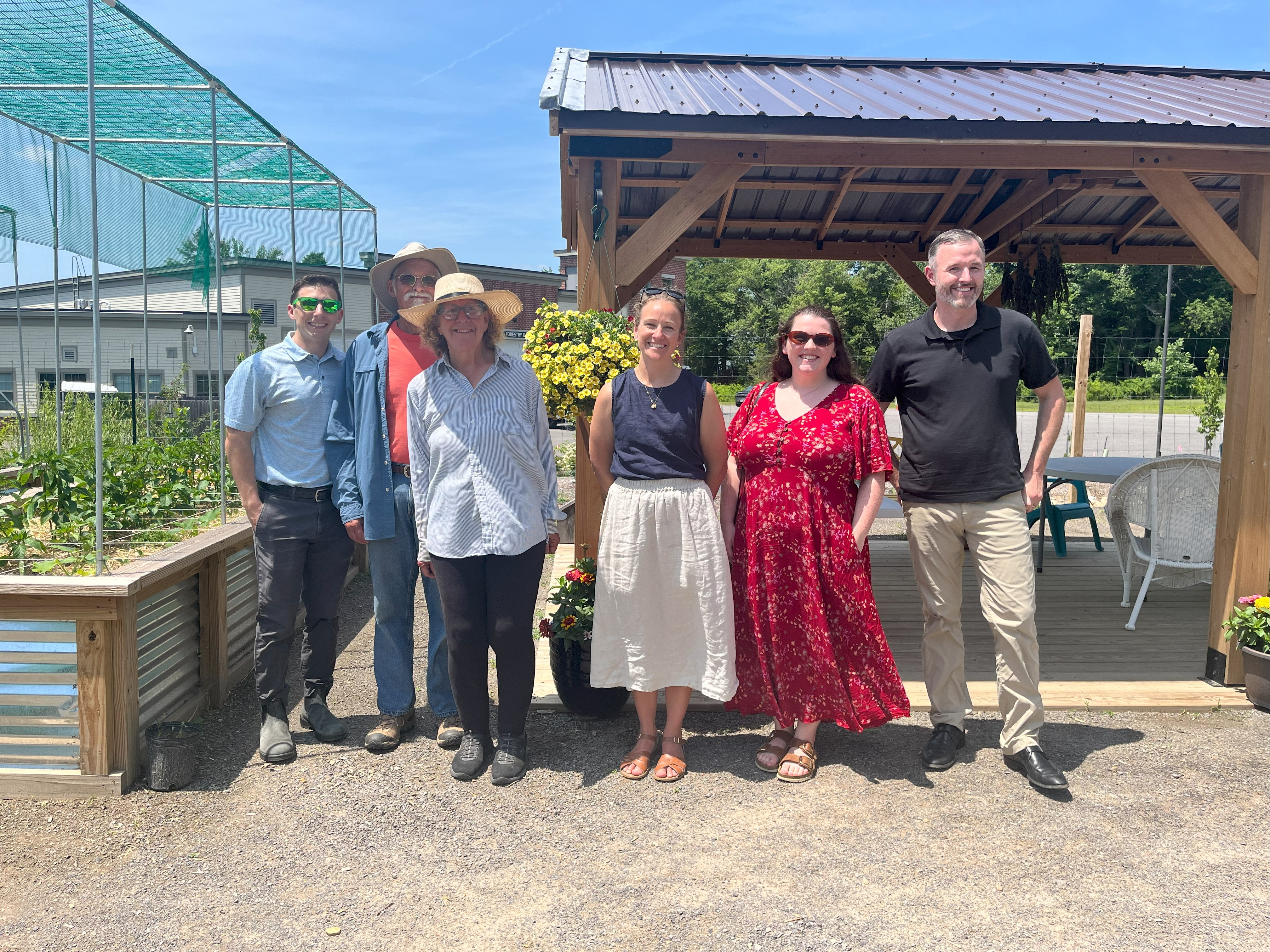 A group photo in a community garden.